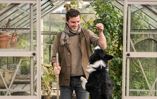 Gill and his dog in front of greenhouse