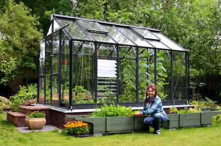 Large greenhouse surrounded by pots and trees