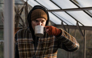 Gill drinking a hot drink in his Rhino greenhouse