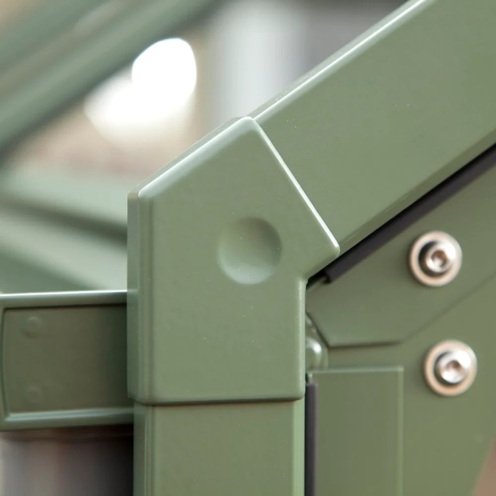Green metal frame, secured with bolts, forms part of a Rhino Greenhouse structure. The angle highlights the intersection of two bars, with a blurred background suggesting an indoor or covered setting.