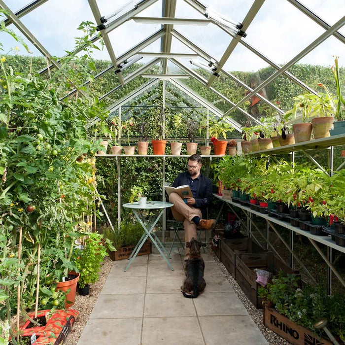 Man reading a book inside his Rhino Greenhouse